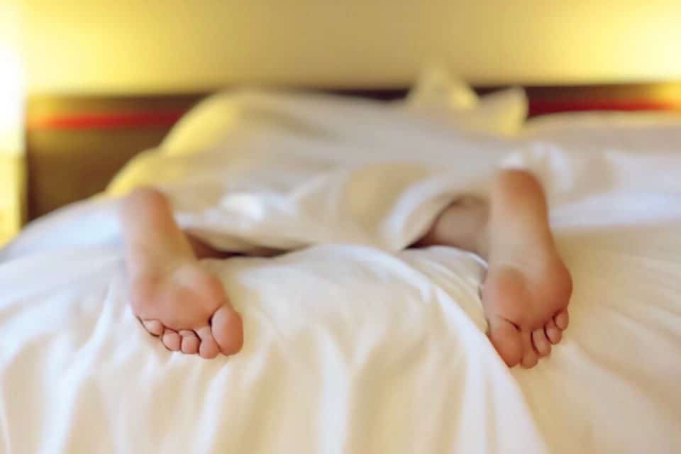 A person's feet sticking out the covers