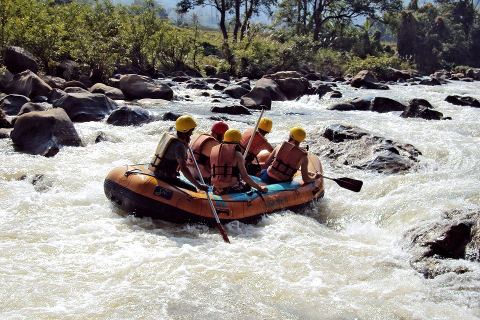 A group of people white water rafting