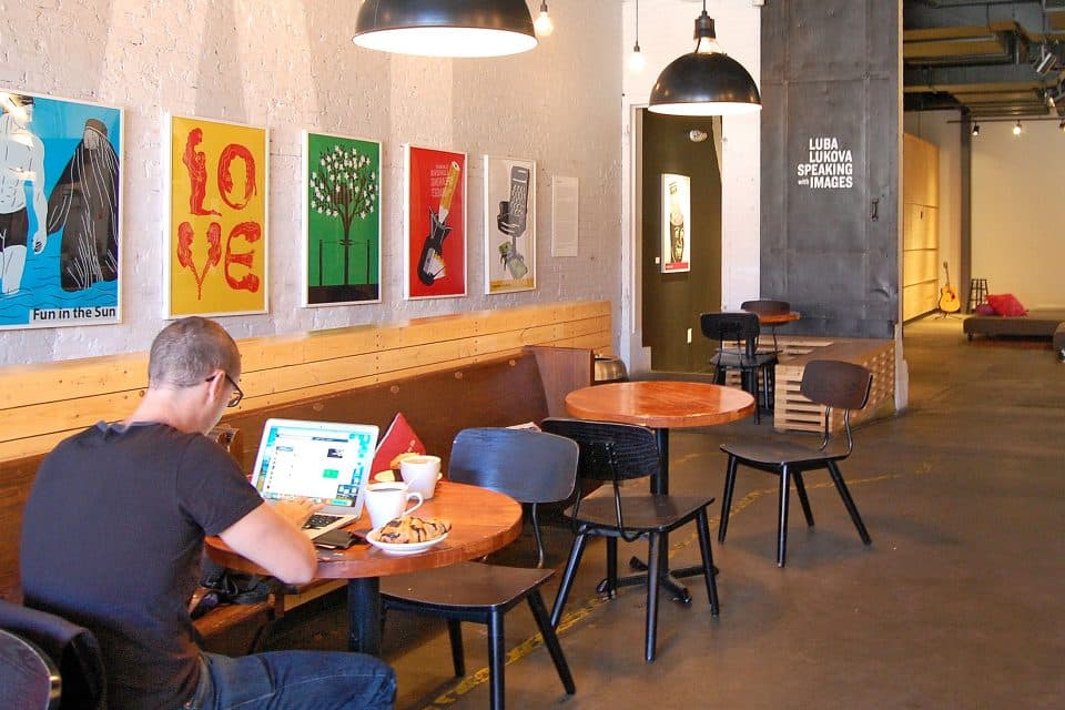 Man sits at laptop in hostel common room