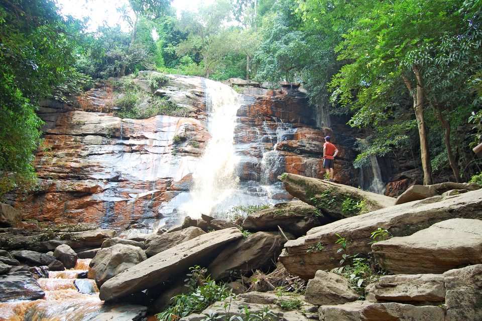 A man standing at a waterfall