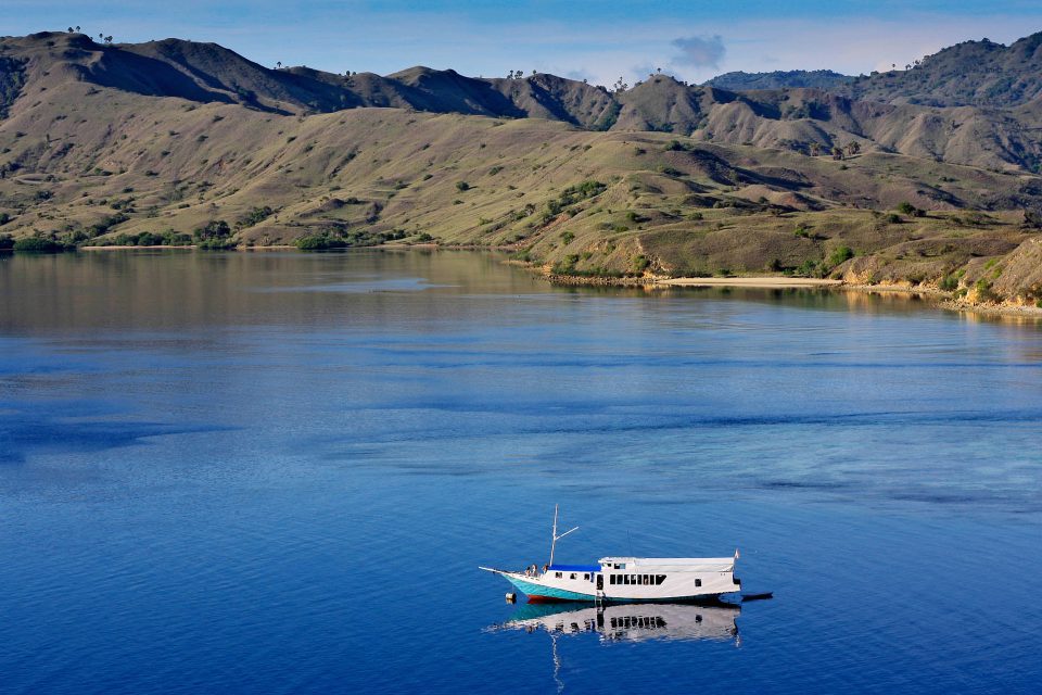 A boat on a lake with mountains behind