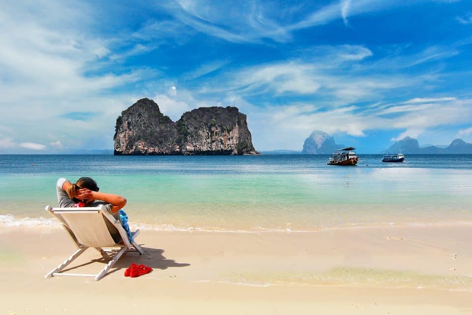 A woman sitting on a deckchair on the beach