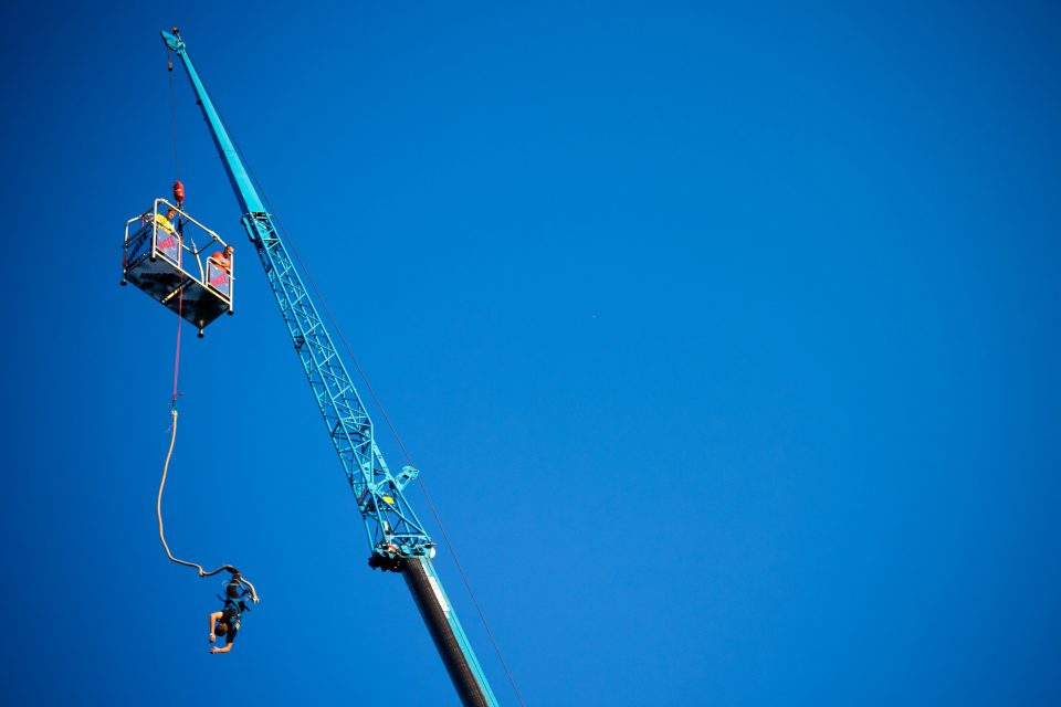 Man bungee jumping off a crane