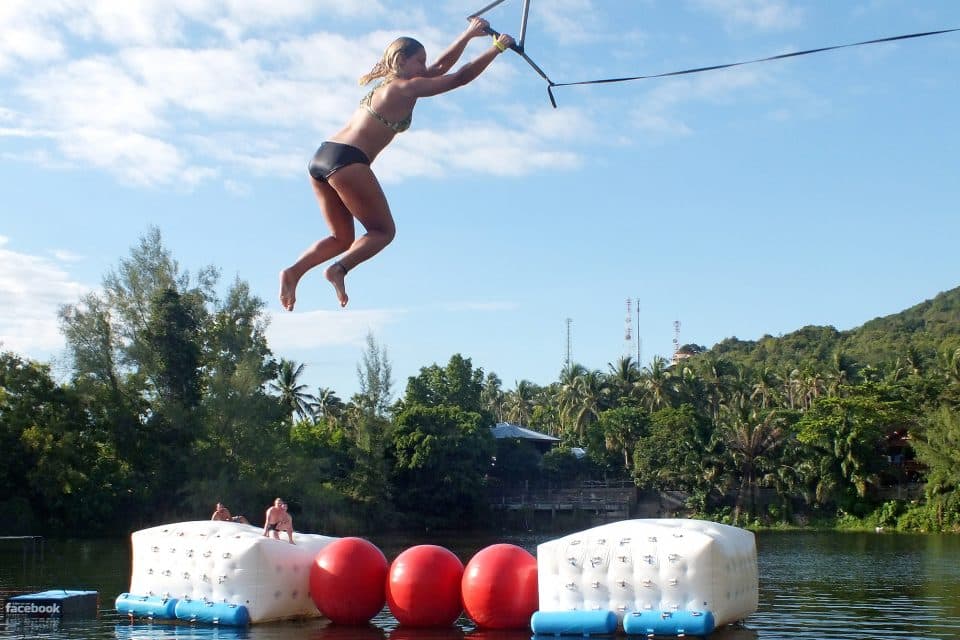 A woman swinging over a lake