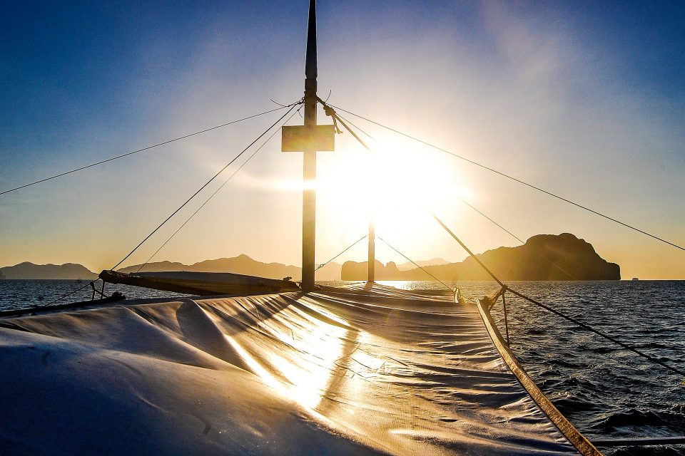 A boat at sea at sunset