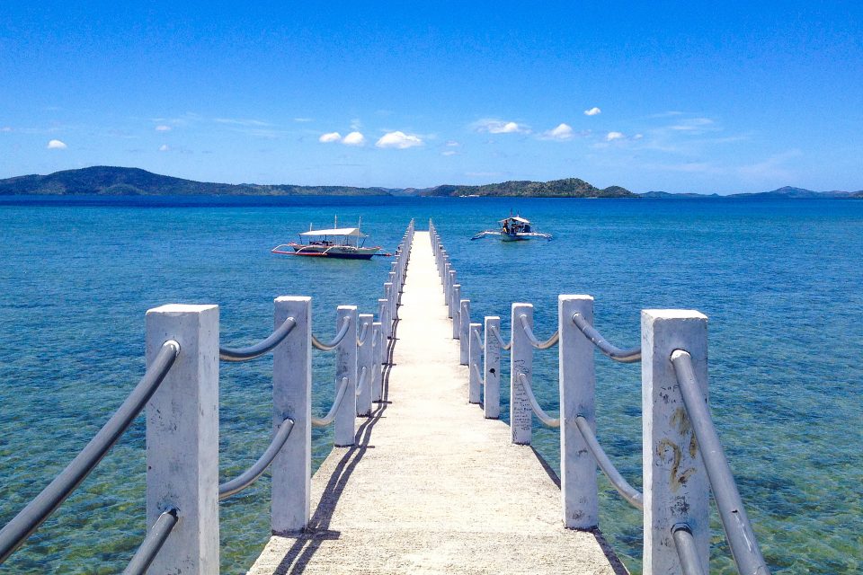A long white pier extending into the sea