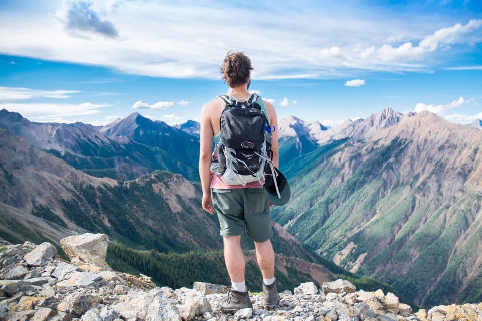 A man wearing a backpack with beautiful landscape views in the ditance 