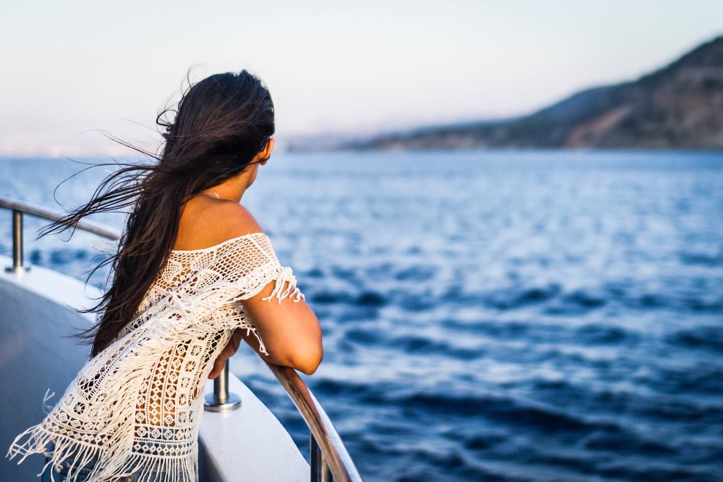 Woman looking out at water from a cruise ship