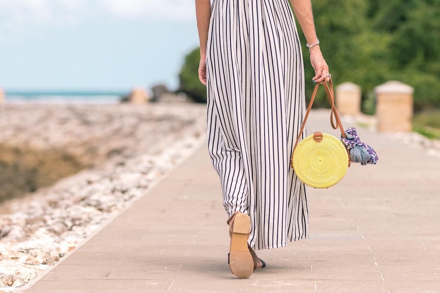 woman walking on boardwalk with bag
