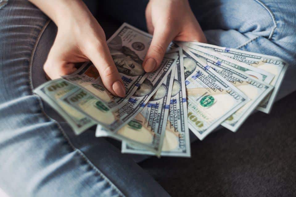 person holding several hundred dollar bills