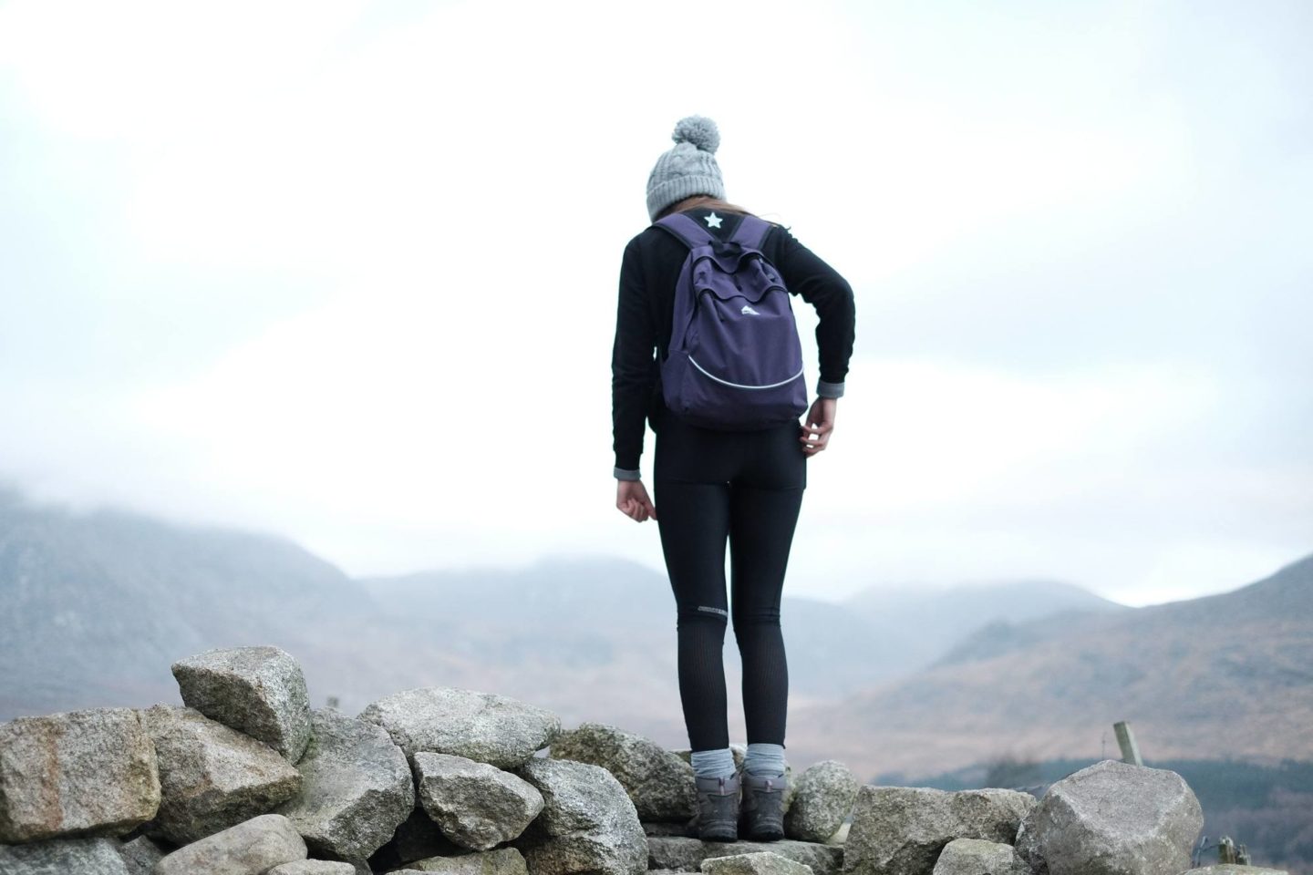 woman standing on top of mountain after hiking