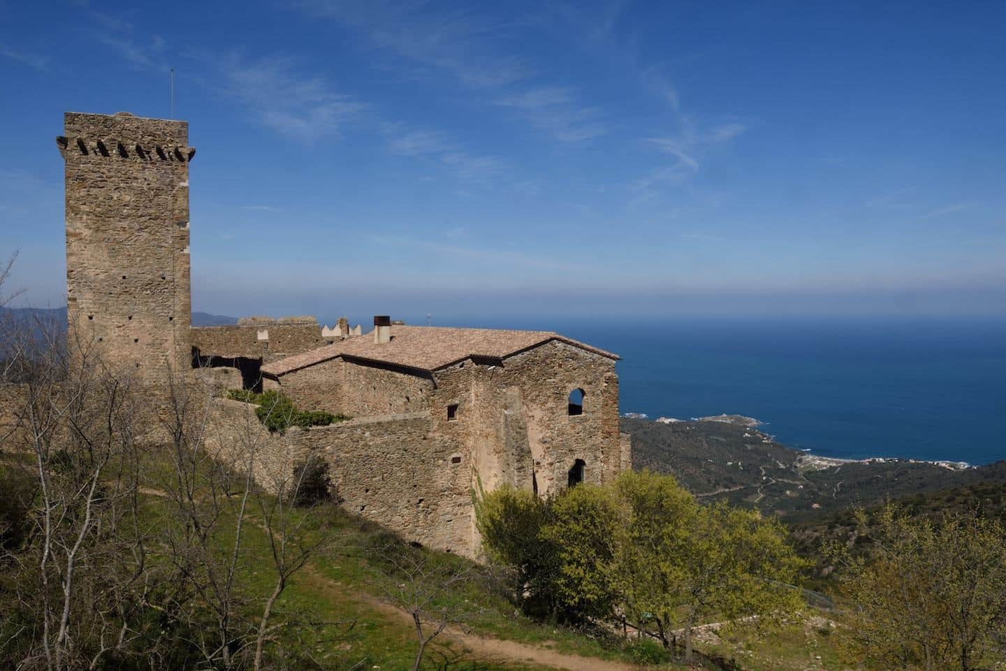 stone monastery in front of sea in spain