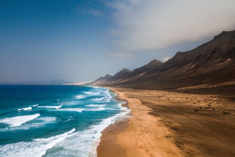 beach with rocky cliffs behind