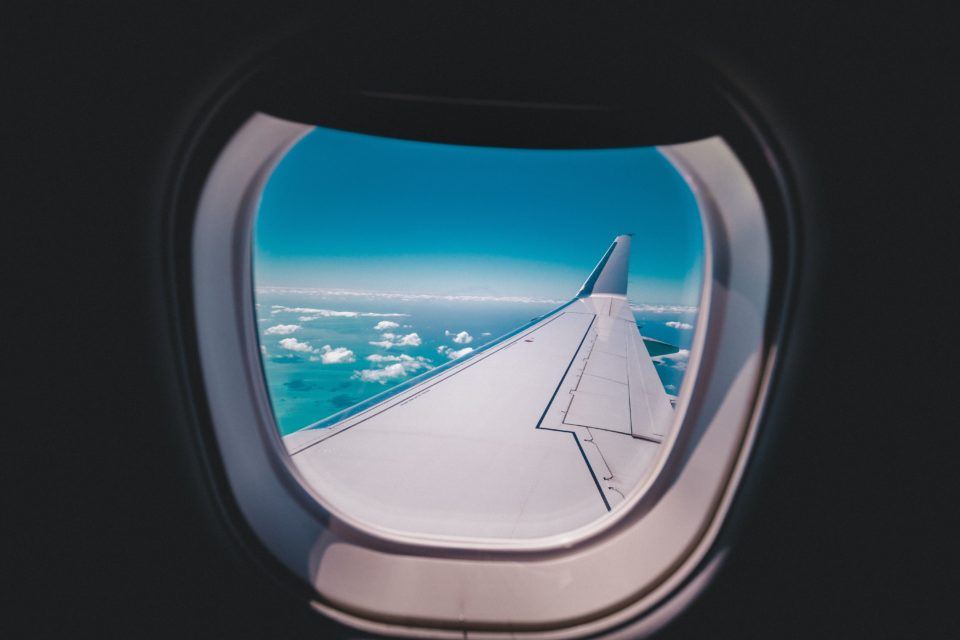 view from outside airplane window of wing and blue sky