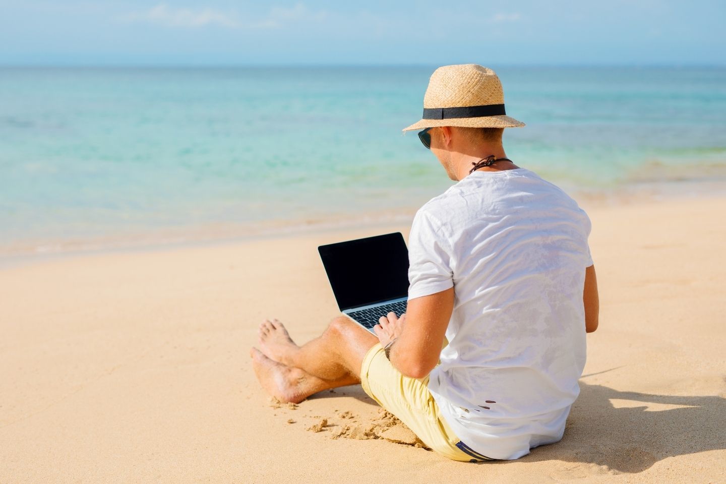 Digital nomad man working on a beach