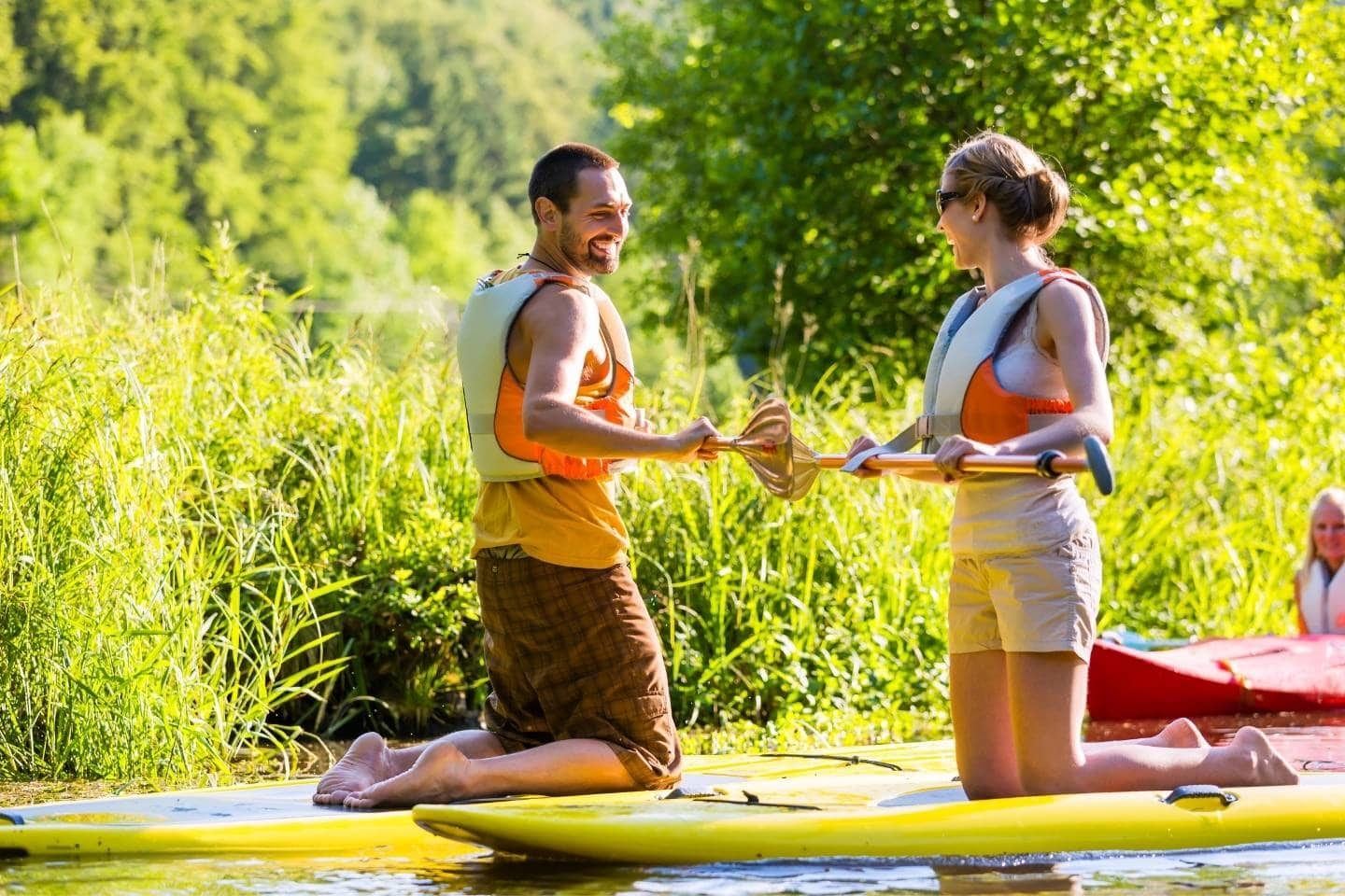 A lady and a man on a SUP paddle board