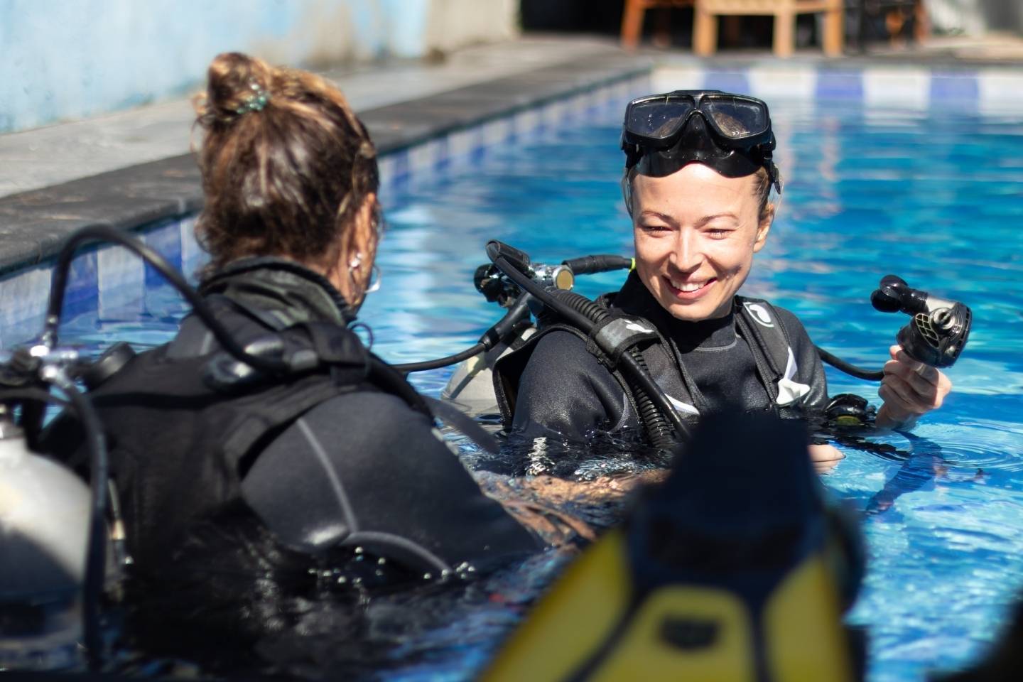 Seorang wanita mendapatkan pengalaman dengan scuba diving di bawah bimbingan instruktur menyelam rekreasi yang berpengalaman di kolam renang